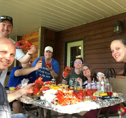 Family eating Maine lobster at the table
